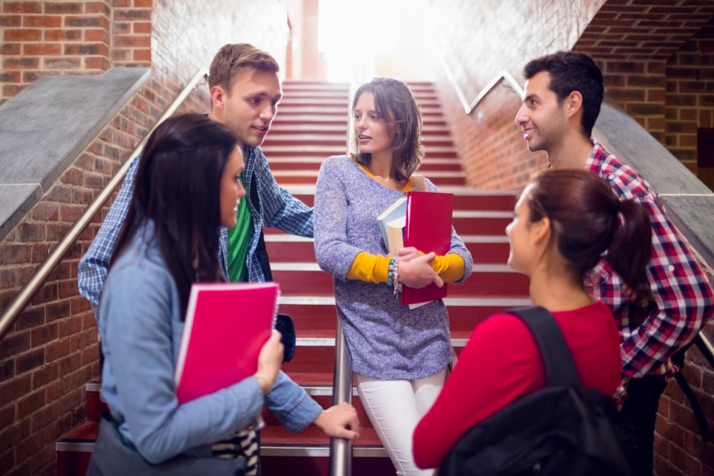 A group of young teenagers are standing on a staircase, discussing unsafe sex. 