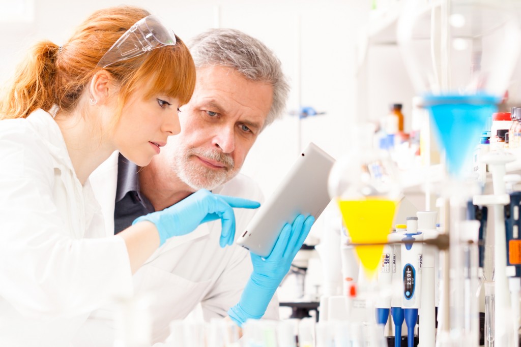 A young female scientist and her senior male supervisor looking at the results from a preclinical trial.