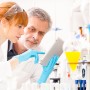 A young female scientist and her senior male supervisor looking at the results from a preclinical trial.