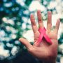 A hand holding an AIDs ribbon to spread awareness about mother-to-child HIV transmission.