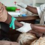 African nurse is drawing blood from african to perform a test, and help in eliminating HIV.